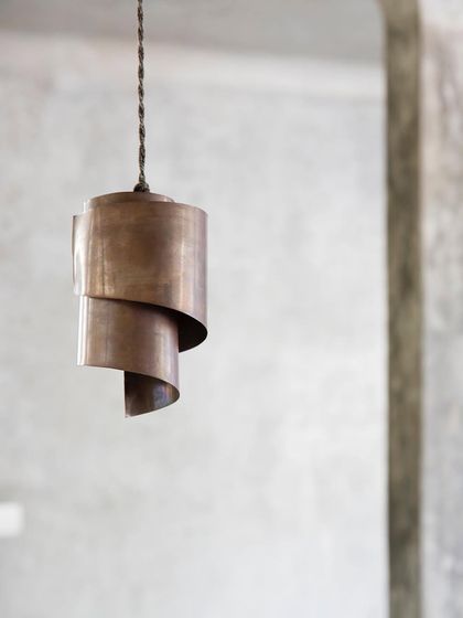 A custom-designed copper pendant light, handcrafted for the project. I often design bespoke fixtures and furniture to ensure every element aligns with the architectural vision.