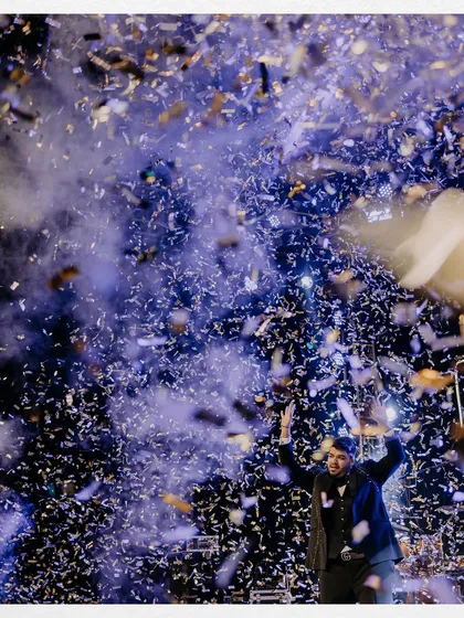 A moment of pure celebration as the groom is showered in confetti on the dance floor, capturing the peak energy of the night.