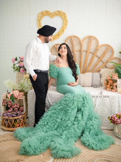 A beautiful portrait of the couple seated together, sharing a quiet moment. The husband looks on with adoration as his wife, the glowing mother-to-be, takes center stage.
