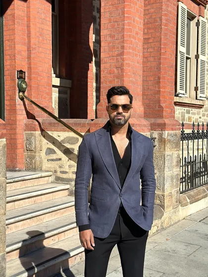 The texture and color of the navy blazer are highlighted in the bright sunlight.