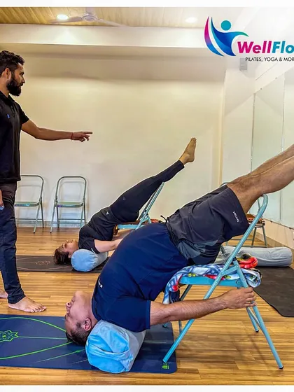 We use props like chairs to make yoga accessible and to help you deepen your practice. Here, our members use chair support for a restorative backbend, which helps to open the chest and improve spinal flexibility safely.