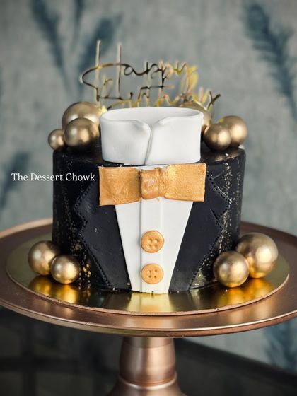 A sharp and stylish tuxedo cake, perfect for the gentleman in your life. This tall chocolate truffle cake is decorated in black and gold for a sophisticated look.