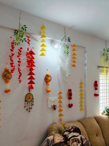 Another angle of the living room decor, showing how the handmade hangings in different colors and shapes create a dynamic and joyful atmosphere.