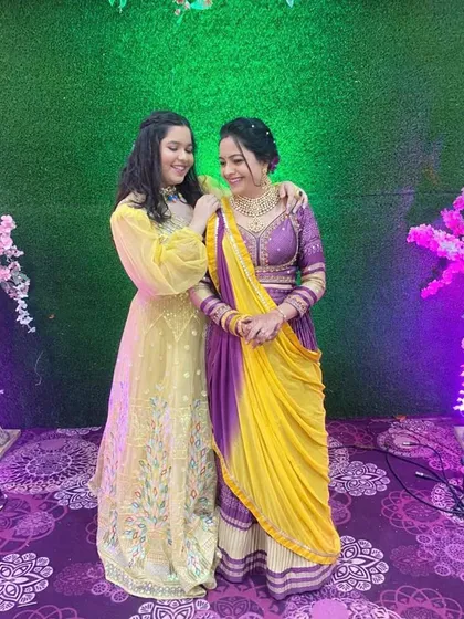 Here you can see how my rental collection caters to the whole family. A daughter in a modern yellow lehenga and a mother in a traditional purple and yellow bandhani lehenga, both looking elegant and festive.