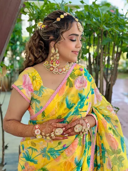 A close-up of the soft Haldi look. The floral saree and matching floral jewelry are complemented by a fresh and dewy makeup application.