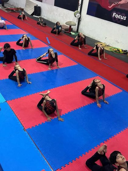 Group conditioning ensures everyone is progressing together. This is a synchronized stretching session where athletes work on their back and leg flexibility, an essential part of our daily warm-up routine.