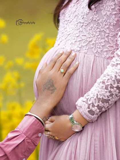 A close-up shot of a couple's hands on the baby bump, a simple and intimate way to capture their connection.