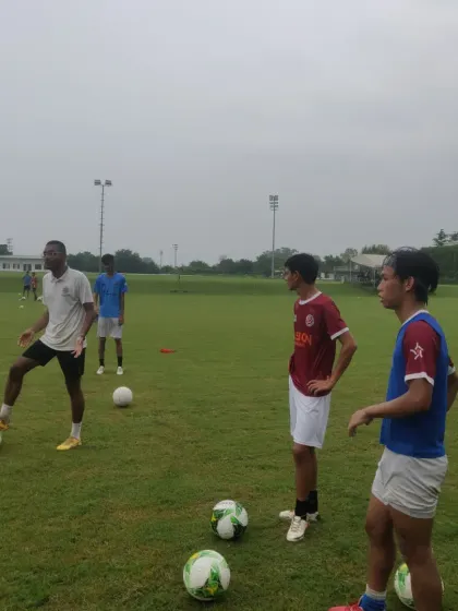 A coach demonstrates a skill while players observe. Learning by example is a powerful tool.