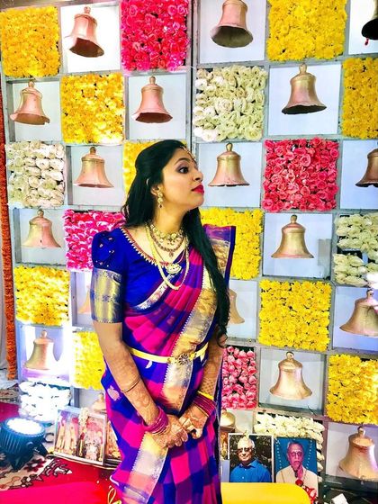 A stylish pose showing off the full look. The puff-sleeve blouse and traditional saree are paired with a soft, glowing makeup look suitable for an engagement.