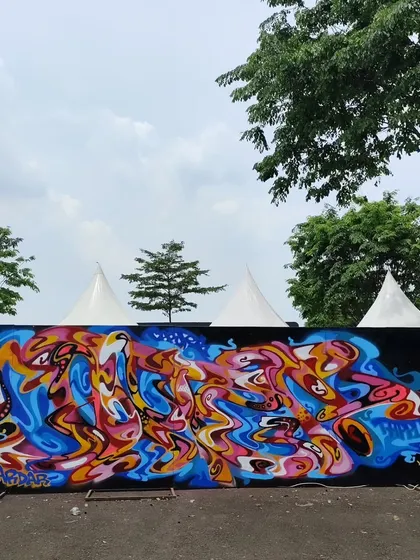 A wider shot of the abstract mural at the festival, with the event tents in the background.