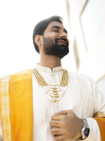 A sun-kissed portrait of the groom, capturing a moment of pure happiness and contentment.