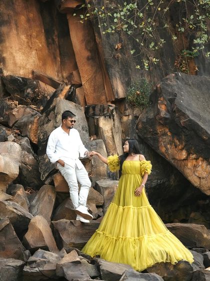 The couple posing together in the rocky terrain, highlighting how my gowns can make any location look magical.