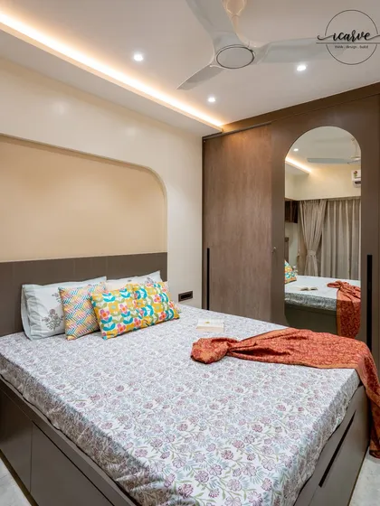 This bedroom features an arched niche above the headboard and a full-length mirror on the wardrobe to create a sense of space.