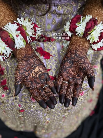The deep, dark stain on a bride's hands, adorned with floral jewelry. This is a picture-perfect mehendi moment.