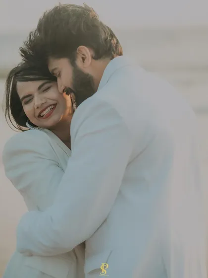 A beautiful, happy embrace captured on the beach. This photo is all about genuine emotion and the warmth of the couple's connection, highlighted by the soft, golden light.