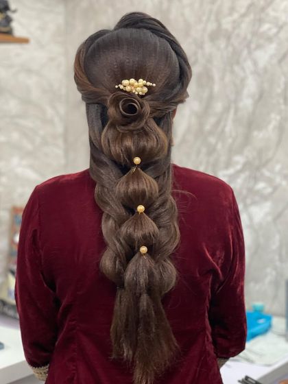A demonstration of an advanced hairstyling technique. This intricate bubble braid with a floral rose detail is perfect for a reception or sangeet.