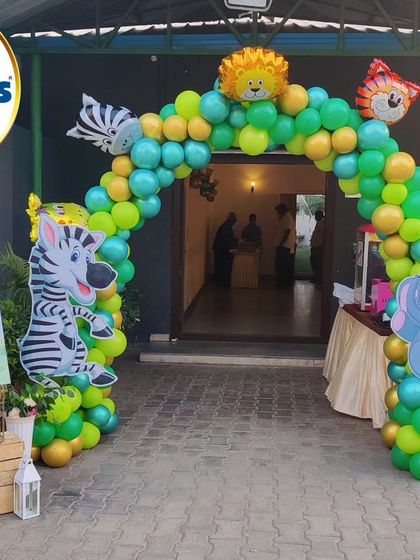 A welcoming balloon arch for a jungle-themed party, decorated with foil animal balloons like a lion, tiger, zebra, and elephant.