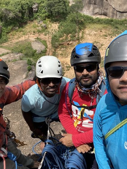 A group selfie from the top of a multi pitch climb. The smiles and stunning backdrop capture the essence of a great day out on the rocks with friends.