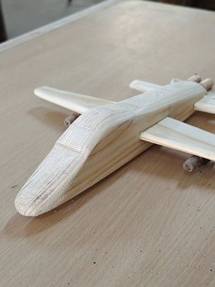 Another look at the handmade wooden airplane. The body is shaped from a solid block of wood, and the wings are carefully attached.