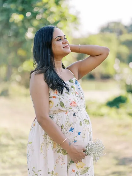 Soaking up the sun during a beautiful outdoor session. This solo portrait captures the mother-to-be in a moment of quiet joy, surrounded by nature.