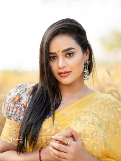 A beautiful close-up portrait in a yellow saree, capturing a warm and engaging expression.