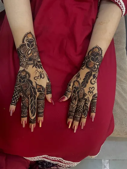 This bold Arabic design looks stunning against the red background, making the dark henna lines pop.