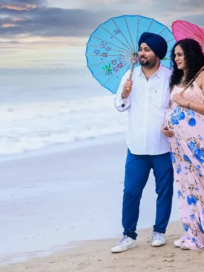 Using colorful umbrellas as props, this couple adds a touch of whimsy and color to their beach photoshoot against a dramatic sky.