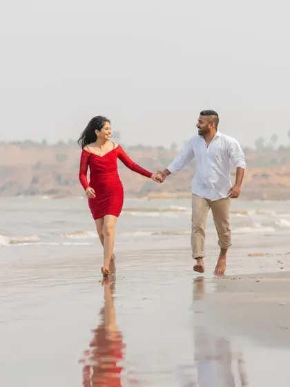 A walk along the shoreline. The reflection in the wet sand and the beautiful coastal backdrop make this a serene and romantic pre-wedding photograph.