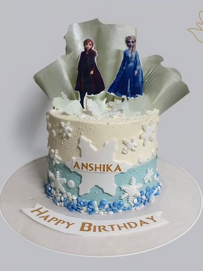 A winter wonderland on a cake, this Frozen-themed creation features Elsa and Anna against a backdrop of edible snowflakes and icy blue details. A perfect cake for a cool celebration.