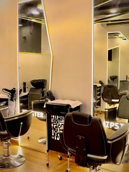 The clean, modern interior of our salon, with full-length mirrors and professional styling chairs ready for your transformation.