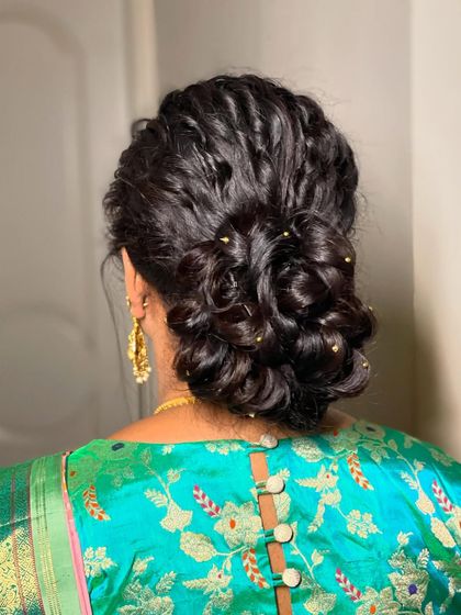 A soft and romantic messy bun, adorned with tiny pearl-like beads. This is a great option for a reception or party.