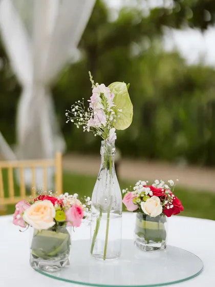 Simple, elegant centerpieces for a daytime event. I love using a mix of small glass vases and bottles with a few select blooms to add a touch of freshness to each table without being overwhelming.