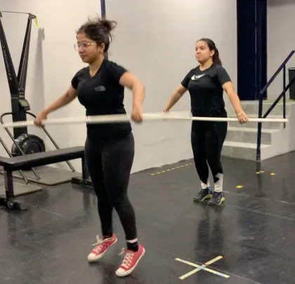Beginners learning the basics of the clean and jerk with PVC pipes during a seminar. These events are open to everyone and are a great way to focus on technique in a supportive environment.