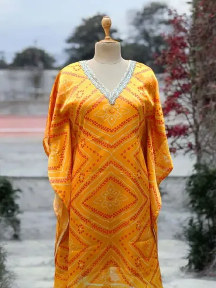 Kaftans have made a grand comeback, combining effortless elegance with supreme comfort. This yellow bandhani print kaftan is a perfect choice for a breezy everyday outfit or a glamorous festive look.