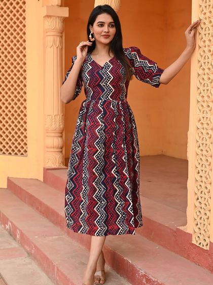 A bold and modern take on the Bagru print, this puff-sleeve cotton dress features a geometric chevron pattern in red and indigo.