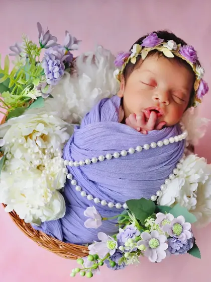 This image captures the baby's tiny hand resting near its mouth, a classic newborn pose that shows their delicate features.