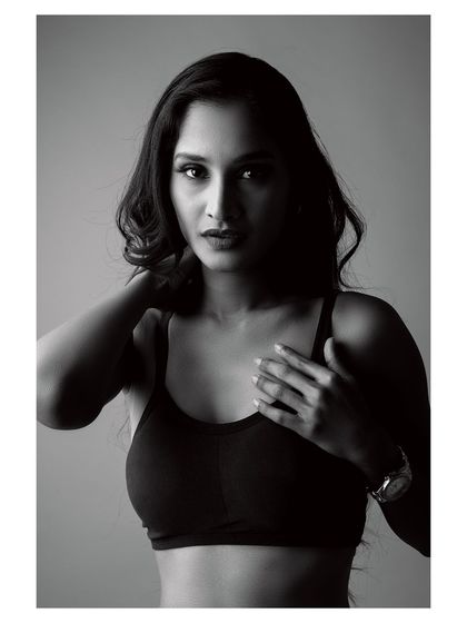 A moody black and white portrait. The lighting creates deep shadows, highlighting the subject's form and creating an image full of emotion and strength.