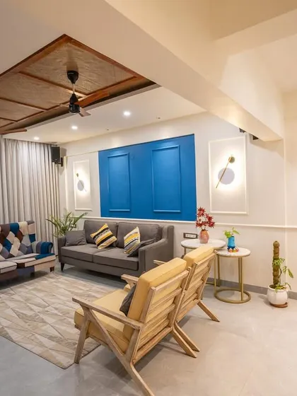 A different perspective of the living room from image 16, highlighting the blue accent wall and the metal wall art.