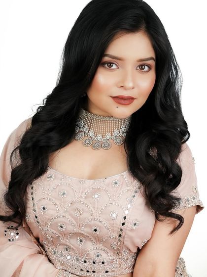 This direct portrait shows the clean skin work and the beautiful matte terracotta lip color.