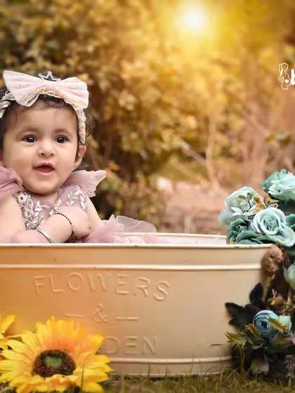 This little one is surrounded by colorful flowers in her outdoor tub photoshoot, looking like a little garden fairy.