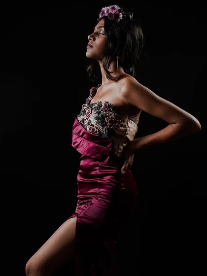 This shot captures the full silhouette of a student's design, themed 'blooming flower'. I used side lighting to sculpt the model's form and bring out the texture of the floral appliqué and satin fabric against a dark background.