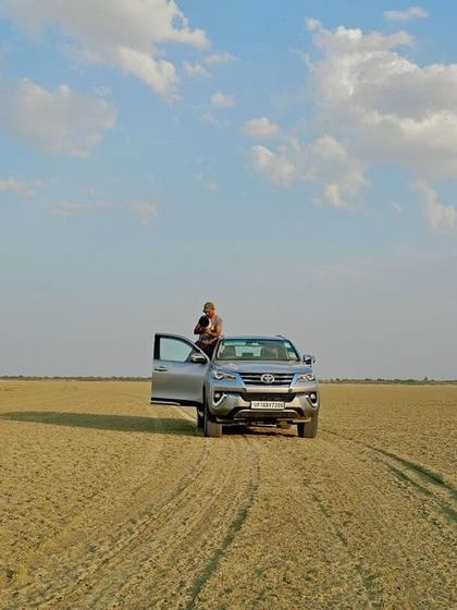 A drone's eye view of me and my vehicle in the vast, empty expanse of the Sambhar Salt Lake. This shows the scale of the landscapes we explore on these specialized tours.