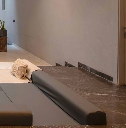 A close-up of the custom-cushioned seating in the sunken lounge, highlighting the use of neutral fabrics and comfortable, relaxed forms.