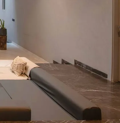 A close-up of the custom-cushioned seating in the sunken lounge, highlighting the use of neutral fabrics and comfortable, relaxed forms.