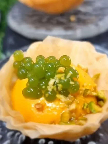 A crispy phyllo cup filled with a creamy mango mousse and topped with basil caviar. This bite combines sweet, savoury, and herbal notes in a surprising way.