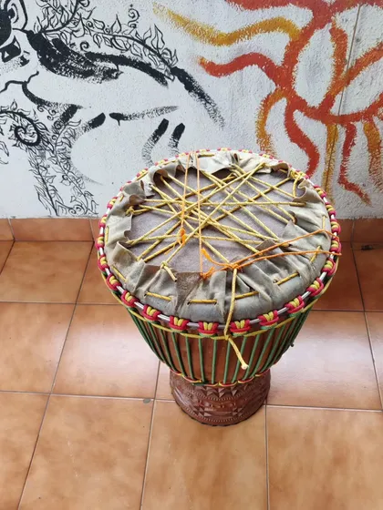 Here you can see the 'dry pull' in progress, which is the toughest part of making a djembe. This traditional West African technique involves weaving and pulling ropes to create the first major tension on the goatskin, setting the foundation for the drum's powerful sound.