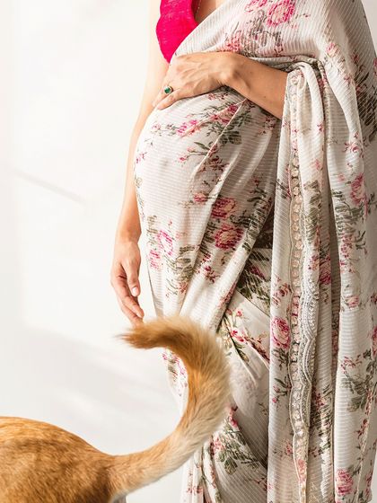 A creative and subtle maternity shot, focusing on the baby bump and the swish of a furry tail. It’s a beautiful, artistic way to include a beloved pet in the pregnancy journey.