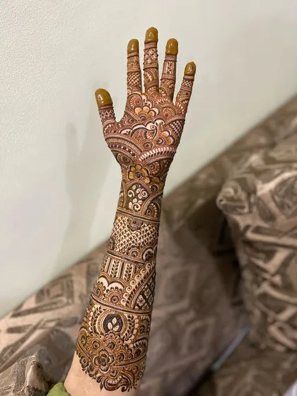 A full-arm bridal design showcasing a variety of intricate patterns. From the palm to the elbow, every inch is covered in beautiful henna.