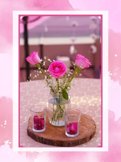 Even the smallest details matter. This simple centerpiece with pink roses in a mason jar adds a rustic and romantic touch to the guest tables at a pastel-themed wedding.