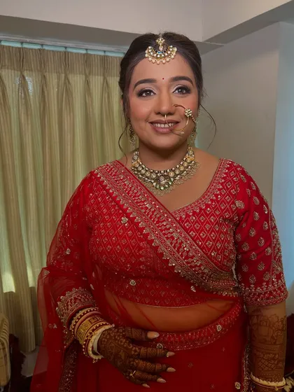 A lovely portrait of the bride, showing how the neat updo works with her dupatta. This traditional bridal hairstyle is a popular choice for its elegance and practicality.